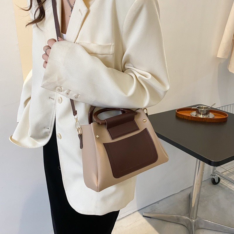 شنطة نسائية أنيقة بمقبض دائري وتصميم لونين مع حزام كتف