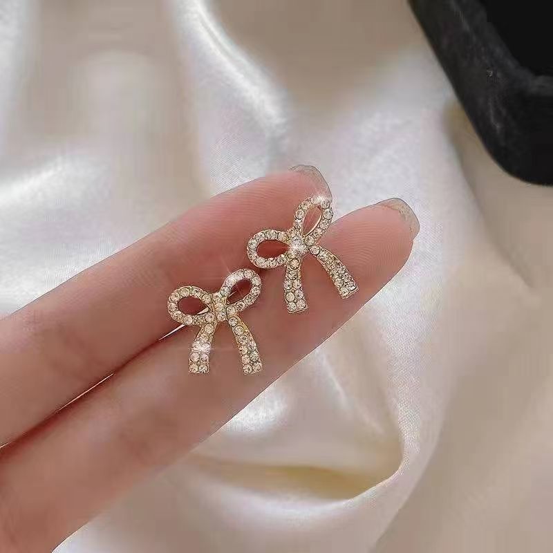 حلق نسائي فيونكة مطلي بماء الذهب مرصع بفصوص لامعة – تصميم أنيق