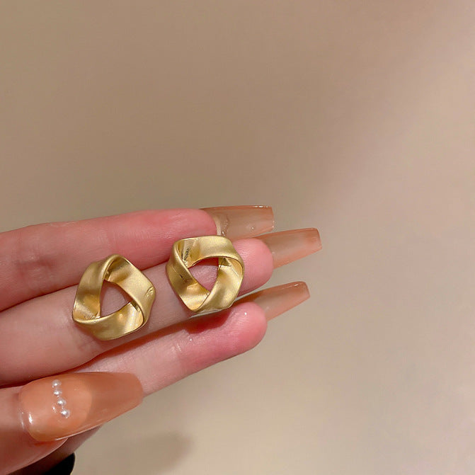 حلق ذهبي بتصميم هندسي ملتف – أناقة عصرية مميزة