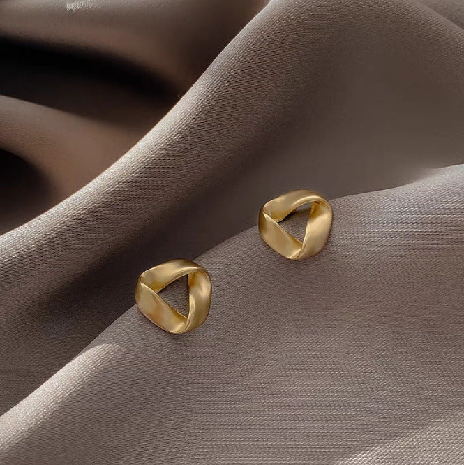 حلق ذهبي بتصميم هندسي ملتف – أناقة عصرية مميزة